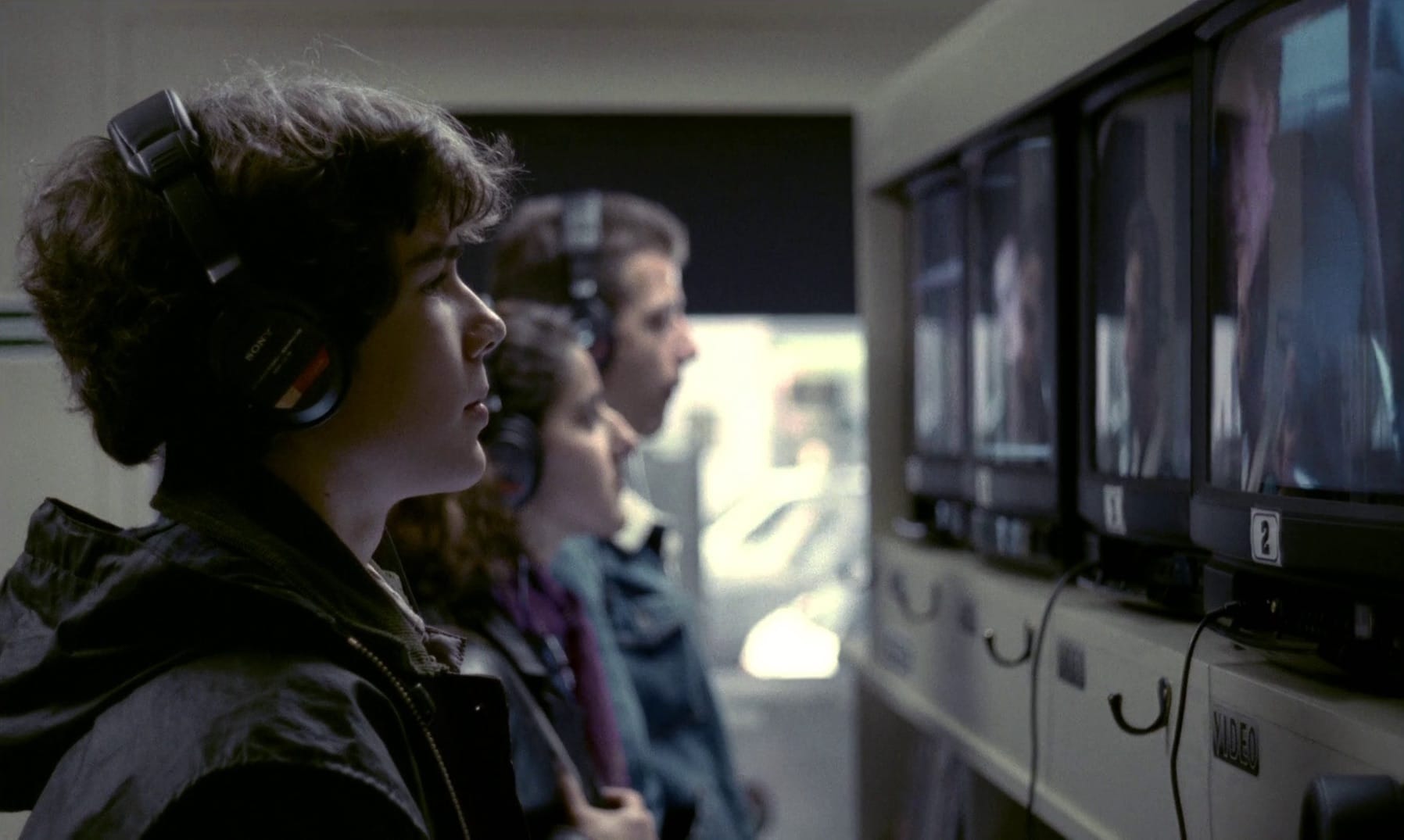 Une rangée de personnes regardant la télévision avec des écouteurs branchés