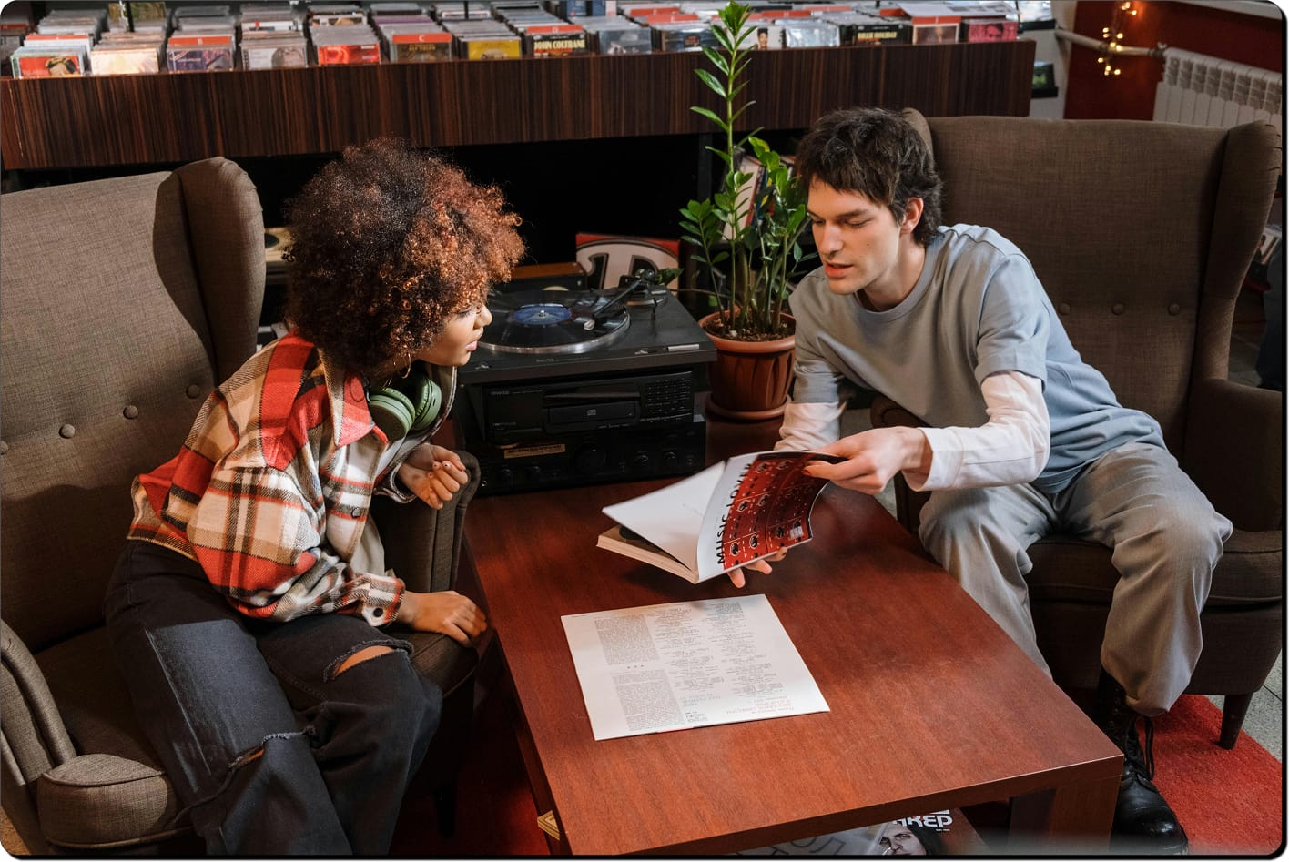 Two people talking over a magazine