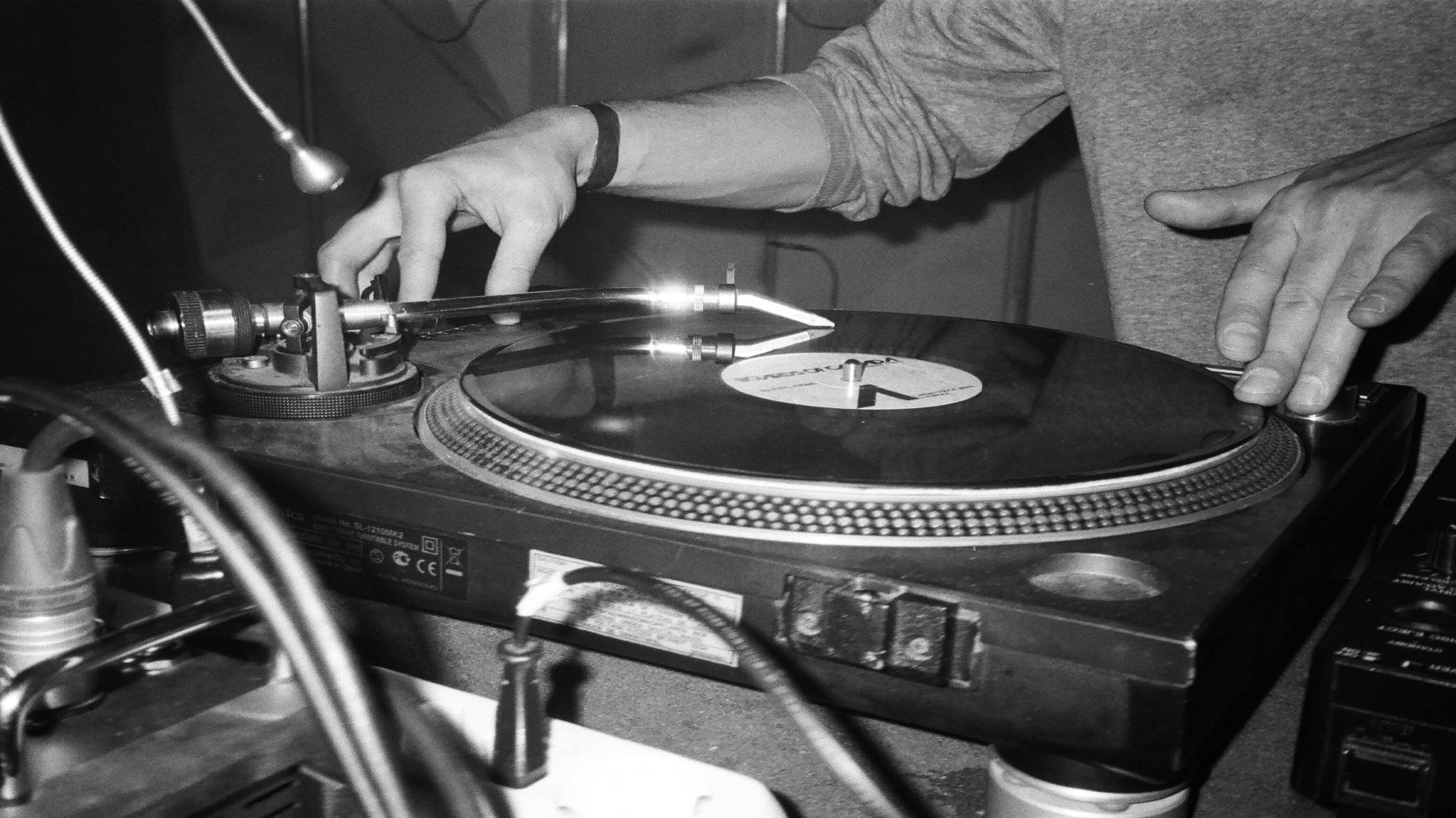 Grayscale Photography of Person Playing Turntable