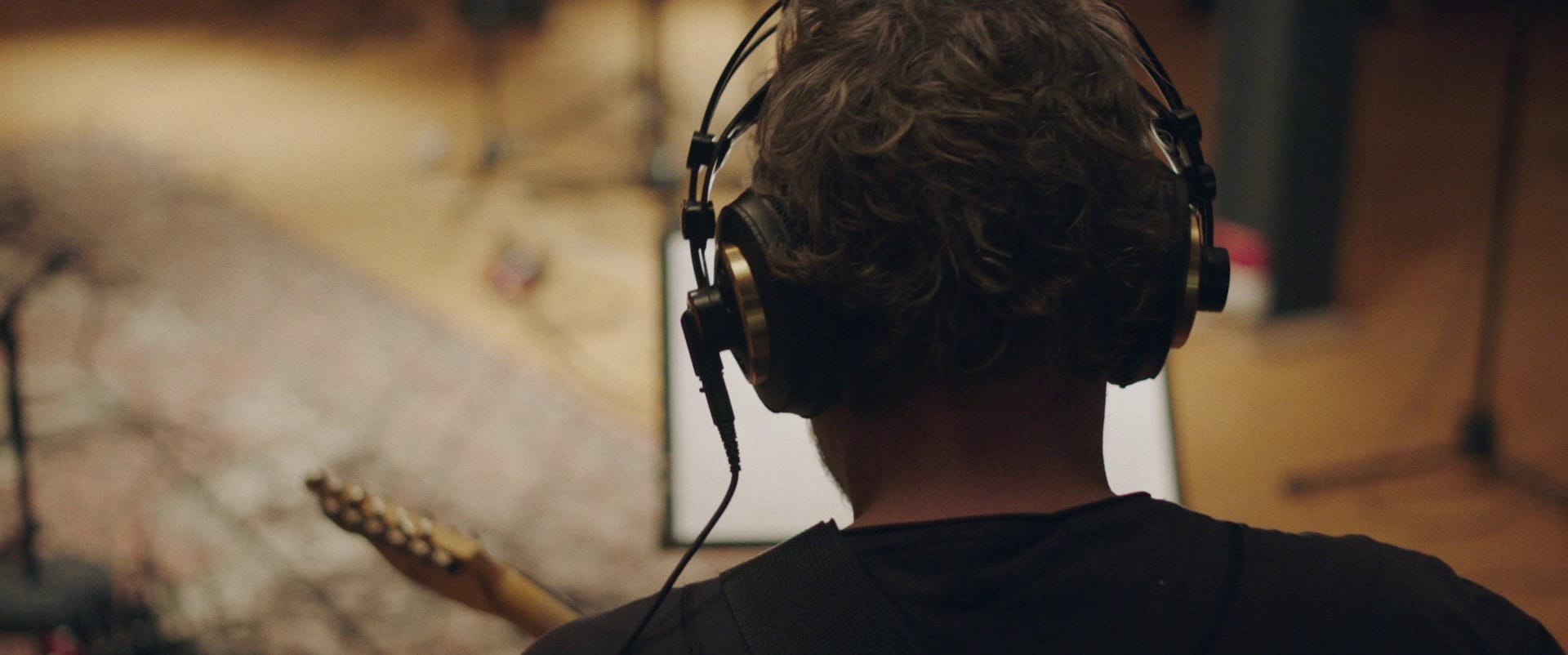 Man recording music with his electric guitar in a cozy studio