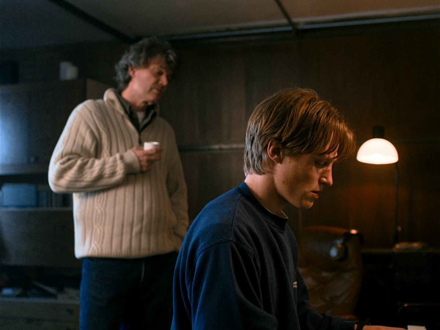 Music teacher watching over his piano student