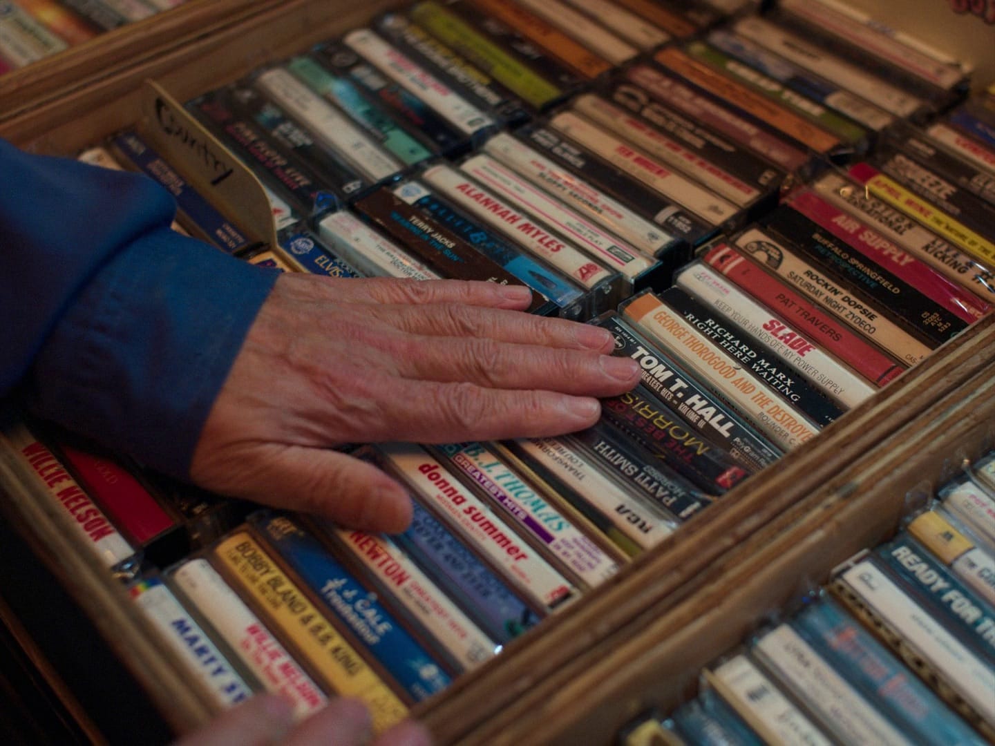 Man’s hand touching a box of CDs