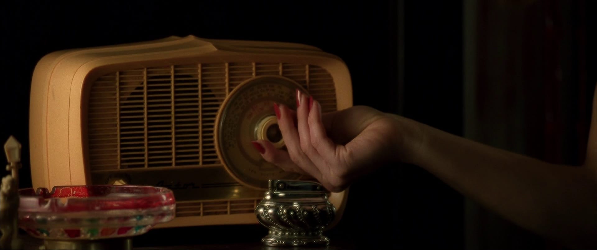 woman’s hand turning on her vintage radio